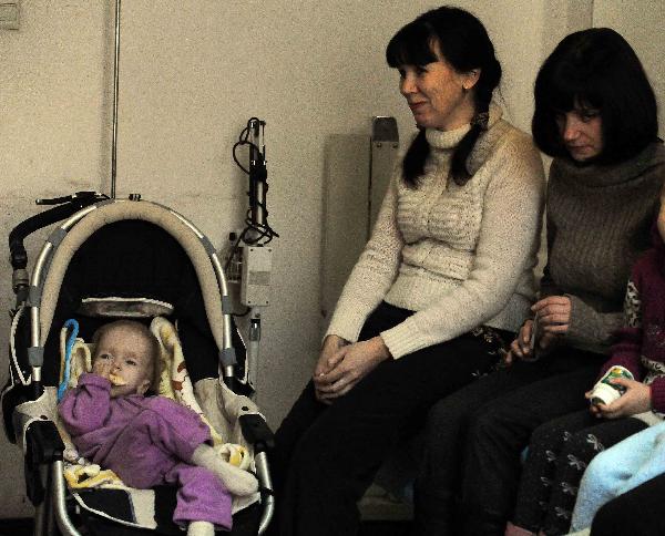 Infant patients and their parents wait for acupuncture treatment to an infant patient in a hospital in Harbin, capital of northeast China's Heilongjiang Province, Nov. 30, 2010. 