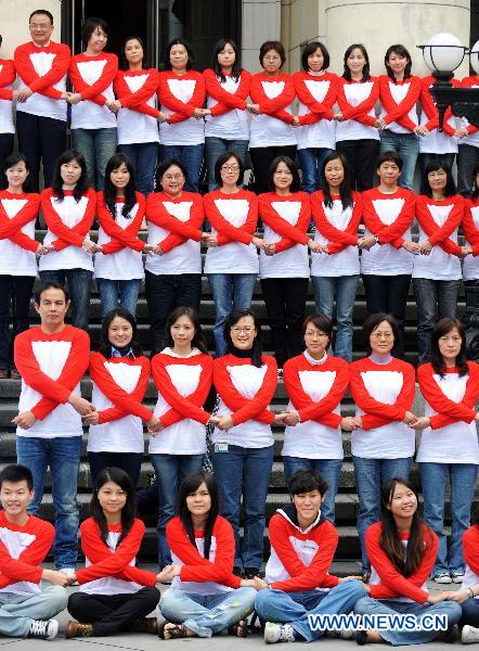 Some 100 'campus ambassadors of AIDS prevention' pose to form the shapes of red ribbons in front of a museum during an activity in Taipei, southeast China's Taiwan, on Nov. 30, 2010, a day ahead of the World AIDS Day. 