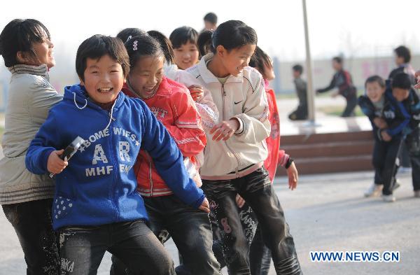 Orphans, whose parents died of AIDS, play a game at the Zhonghua Red Ribbon Home, an orphanage in Shangcai County, central China's Henan Province, Nov. 30, 2010.