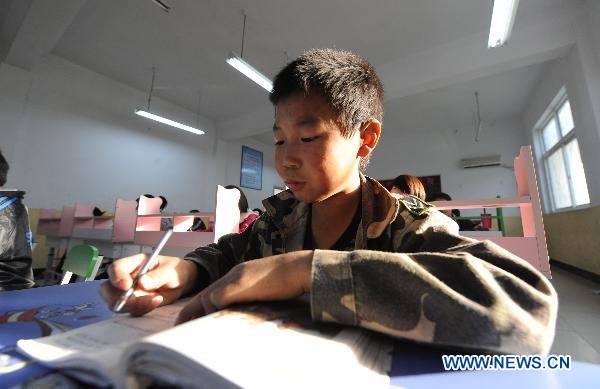 A boy, whose parents died of AIDS, attends class at the Zhonghua Red Ribbon Home, an orphanage in Shangcai County, central China's Henan Province, Nov. 30, 2010.