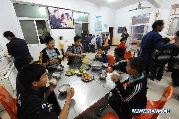 Orphans, whose parents died of AIDS, have dinner at the Zhonghua Red Ribbon Home, an orphanage in Shangcai County, central China's Henan Province, Nov. 30, 2010.