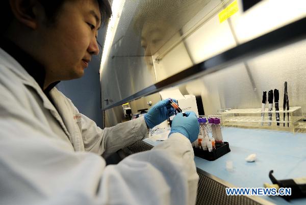 Ning Tielin, a staff member of the AIDS/STD station of the Tianjin centers for Disease Control and Prevention, works at a laboratory in Tianjin, north China, Nov. 30, 2010. 