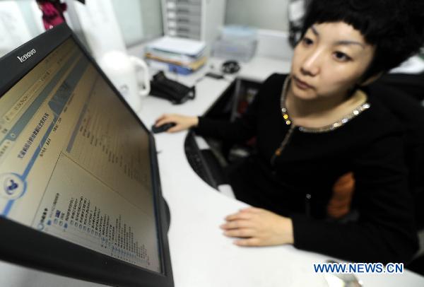 Dong Xiaoyue, a staff member of the AIDS/STD station of the Tianjin centers for Disease Control and Prevention, writes an information report in Tianjin, north China, Nov. 30, 2010. 