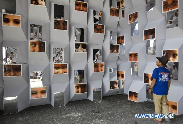 A man looks at wall of photos in the climate village during the United Nations Framework Convention on Climate Change (COP-16), in the Mexican seaside resort of Cancun, on Nov. 30, 2010.