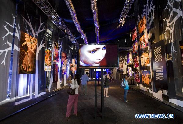 People enjoy an exhibition of photos in the climate village during the United Nations Framework Convention on Climate Change (COP-16), in the Mexican seaside resort of Cancun, on Nov. 30, 2010. 