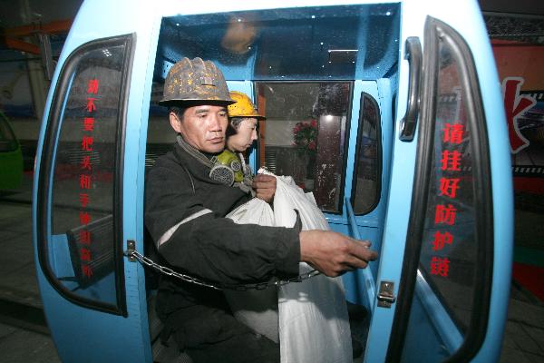 Workers get on a cable car down to the pit at the coal mine of the Henan Yima Coal Group in Gengcun Village, Sanmenxia City, central China's Henan Province, Nov. 30, 2010. 