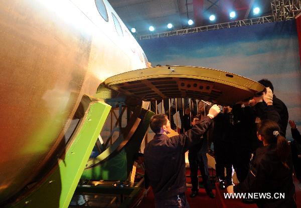 Staff members close the cargo door on the aluminum-lithium alloy fore part of the airframe of C919 jumbo jet, which is manufactured by Hongdu Aviation Industry Group, in Nanchang, capital of east China&apos;s Jiangxi Province, Dec. 1, 2010. 