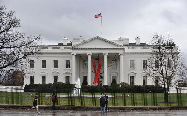 A red AIDS ribbon hangs in front of the White House in recognition of the World AIDS Day, in Washington D.C., capital of the United States, Dec. 1, 2010. 
