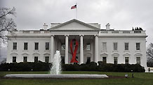 A red AIDS ribbon hangs in front of the White House in recognition of the World AIDS Day, in Washington D.C., capital of the United States, Dec. 1, 2010.