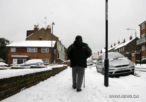 A pedestrian walks on the snow-covered street in southern London, Britain, Dec. 2, 2010.