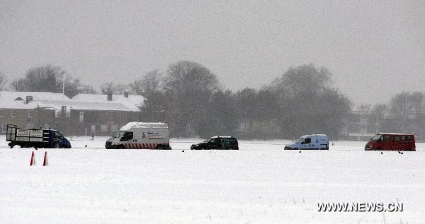Vehicles run slowly on a snow-covered road in southern London, Britain, Dec. 2, 2010. 