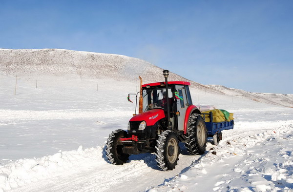 A tractor plows a snow-covered road in Hinggan League Right Wing Front Banner on Dec 2, 2010.