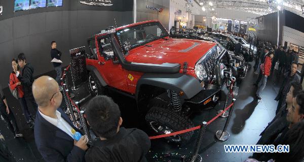 Visitors look at a Jeep vehicle at the 6th China Changsha International Auto Show held in Changsha, capital of central China's Hunan Province, Dec. 2, 2010.