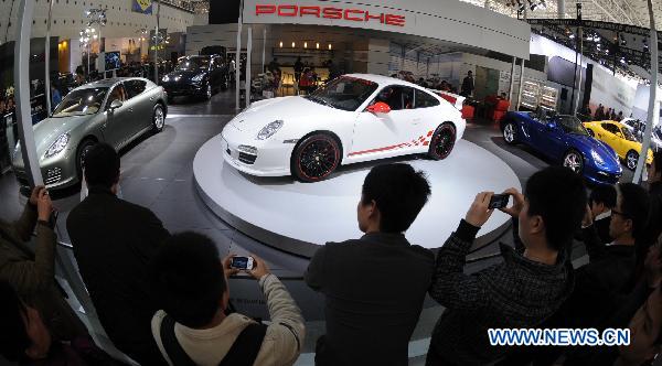 Visitors take photos of Porsche cars at the 6th China Changsha International Auto Show held in Changsha, capital of central China's Hunan Province, Dec. 2, 2010. 