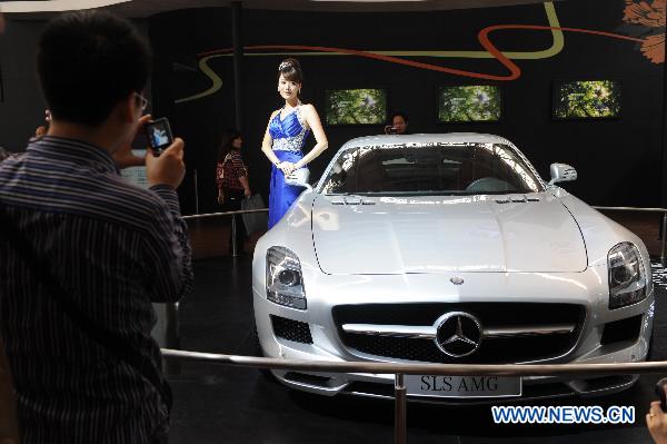 A visitor takes photos of a Mercedes-Benz car at the 6th China Changsha International Auto Show held in Changsha, capital of central China's Hunan Province, Dec. 2, 2010.