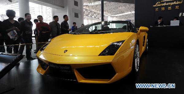 Visitors look at a Lamborghini car at the 6th China Changsha International Auto Show held in Changsha, capital of central China's Hunan Province, Dec. 2, 2010.