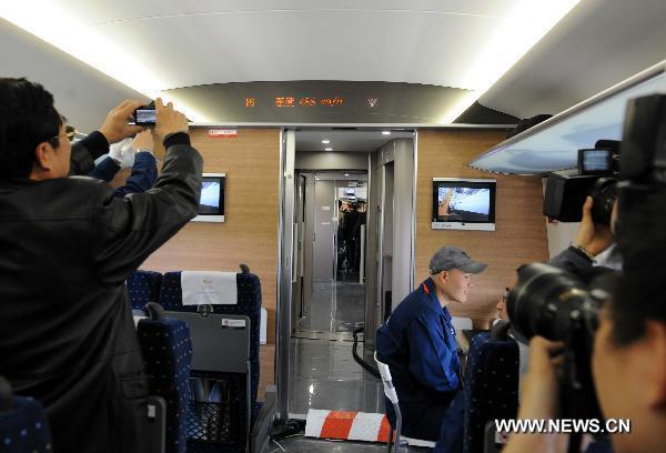 Reporters take photos in the train CRH380A of China Railway High-Speed (CRH), which runs between the north China's Zaozhuang city and Bengbu in the south, a segment of the Beijing-Shanghai high-speed rail line, Dec. 3, 2010. 