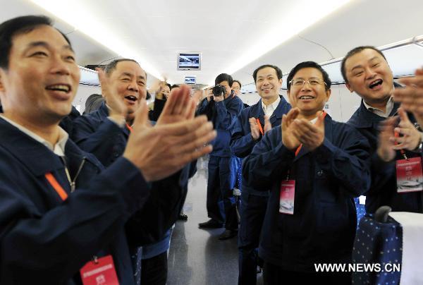 Technicians applaud in the train CRH380A of China Railway High-Speed (CRH), which runs between the north China's Zaozhuang city and Bengbu in the south, a segment of the Beijing-Shanghai high-speed rail line, Dec. 3, 2010. 