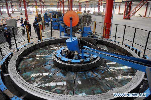 Workers operate at the plant of the Marcegaglia (China) Co., LTD. in Yangzhou, east China's Jiangsu Province, Dec. 3, 2010.