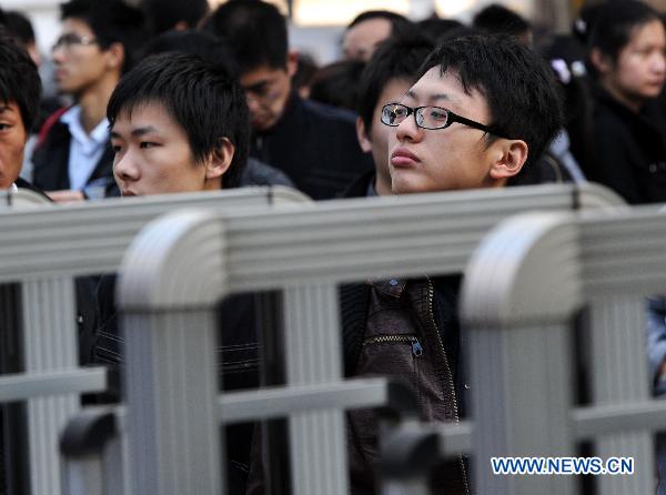 Participants wait to enter the examination site before the first section of the annual national examination to select public servants in Nanjing, capital of east China's Jiangsu Province, Dec. 5, 2010. 