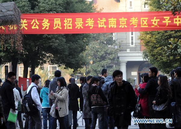 Participants wait to enter the examination site before the first section of the annual national examination to select public servants in Nanjing, capital of east China's Jiangsu Province, Dec. 5, 2010. 