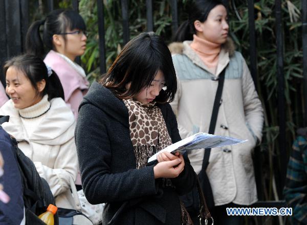 An examinee prepares while waiting to enter the examination site before the first section of the annual national examination to select public servants in Nanjing, capital of east China's Jiangsu Province, Dec. 5, 2010. Over 1.4 million people across China sit in the country's national examination on Sunday. 