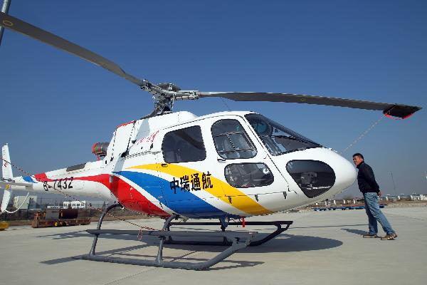 A staff member passes by a helicopter purchased by Huaxi Village for tourism, in Jiangyin, east China's Jiangsu Province, Dec. 5, 2010. 