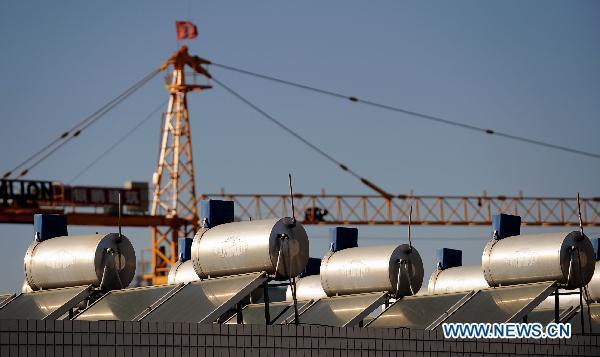 Photo taken on Dec. 4, 2010 shows tanks of solar water heater atop a residential building in Kunming, capital of southwest China&apos;s Yunan Province. 