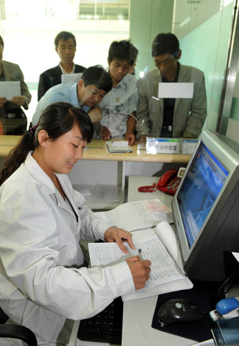 A worker at the medical clearance center in Shenmu County, Shaanxi Province, processes refund registrations for local residents' medical expenses.