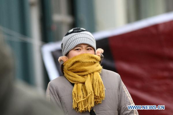 A citizen is seen in thick clothes on the street in Yantai, east China&apos;s Shandong Province, Dec. 6, 2010. 