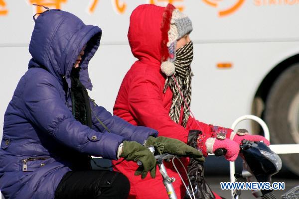People are seen in thick clothes on the street in Lianyungang, east China&apos;s Jiangsu Province, Dec. 6, 2010. 
