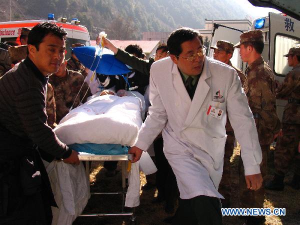 Paramedics transfer an injured man onto a helicopter in Kangding, southwest China's Sichuan Province, Dec. 6, 2010. Four injured people in the wild fire in Daofu County have been transfered to the hospitals in Chengdu by helicopters to receive further medical treatment on Monday. [Xinhua] 