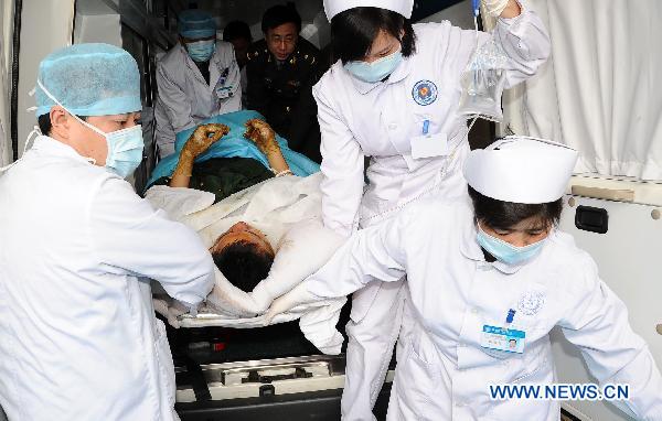 Paramedics transfer an injured man into a hospital in Chengdu, southwest China's Sichuan Province, Dec. 6, 2010. Four injured people in the wild fire in Daofu County have been transfered to the hospitals in Chengdu by helicopters to receive further medical treatment on Monday. [Xinhua]