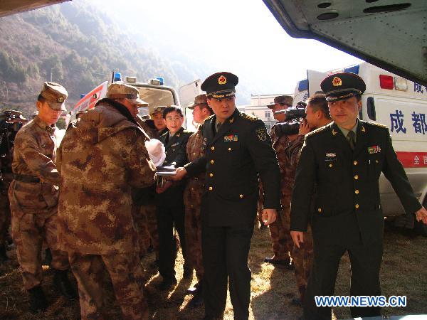 Officers of the People's Liberation Army help to transfer an injured man onto a helicopter in Kangding, southwest China's Sichuan Province, Dec. 6, 2010. Four injured people in the wild fire in Daofu County have been transfered to the hospitals in Chengdu by helicopters to receive further medical treatment on Monday. [Xinhua]