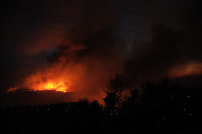 Fire is seen near Isfiya, on Mount Carmel, near Haifa, north Israel, Dec. 5, 2010. After more than three days&apos; arduous battle, Israeli firefighting authority announced Sunday afternoon that it had fully contained the inferno, according to local news service Ynet. [Xinhua]