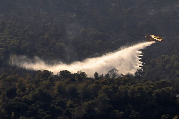 A fire-fighting aircraft drops water over a forest fire near Isfiya, on Mount Carmel, near Haifa, north Israel, Dec. 5, 2010. After more than three days&apos; arduous battle, Israeli firefighting authority announced Sunday afternoon that it had fully contained the inferno, according to local news service Ynet. [Xinhua]
