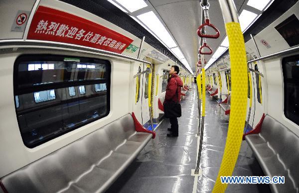 A visitor experiences the interior of the first train Changchun Railway Vehicles Company manufactured for MTR Corporation's West Island Line (WIL) project in Changchun, northeast China's Jilin Province, Dec. 6, 2010. 