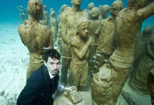 A young man dressed in everyday wear, dives amongst the statues at the underwater art installation, Silent Evolution in Cancun, Mexico, on Dec. 6, 2010. 