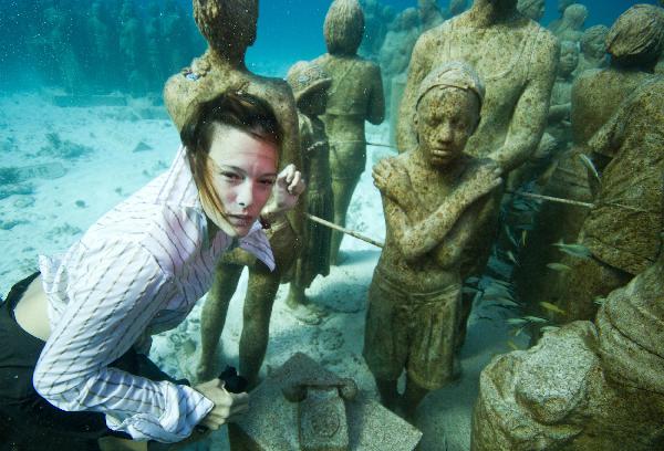 A young woman dressed in everyday wear, dives amongst the statues at the underwater art installation, Silent Evolution in Cancun, Mexico, on Dec. 6, 2010. 