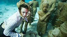 A young woman dressed in everyday wear, dives amongst the statues at the underwater art installation, Silent Evolution in Cancun, Mexico, on Dec. 6, 2010.