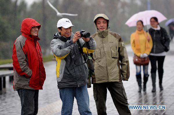 Visitors take photos at Dianchi Lake in Kunming, southwest China's Yunnan Province, Dec. 7, 2010. 