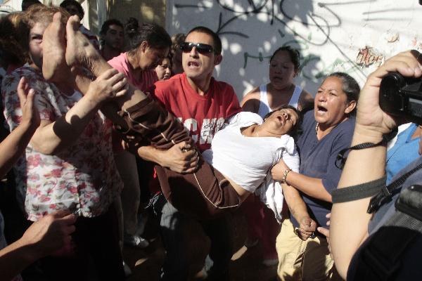 Relatives of inmates react outside San Miguel public prison, after a fire broke out in the building, killing 81 inmates, in Santiago December 8, 2010. 