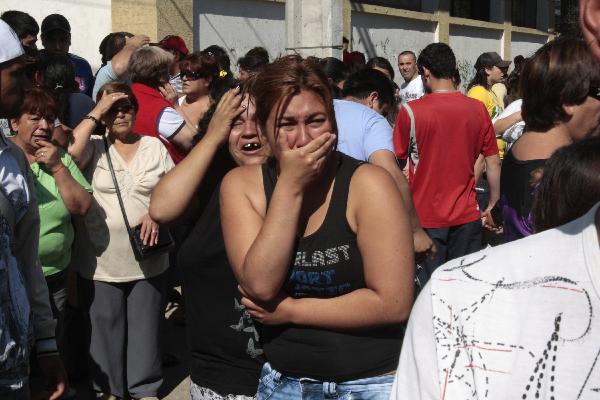 Relatives of inmates at the San Miguel prison react as they listen the list of names of inmates who died in a fire in Santiago, Chile, Wednesday Dec. 8, 2010. 