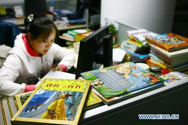 A staff member of Dangdang.com, the No. 1 business-to-consumer brand in China, which is also labeled as 'China's Amazon' by many investors, works as many newly-published books are piled up around her, at Dangdang's office in Beijing, capital of China, Dec. 9, 2010. 