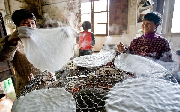 Villagers arrange final products of Tenggeng, a traditional snack made of rice, in the Sizhai Village of Zhuji City, east China's Zhejiang Province, Dec. 8, 2010. 