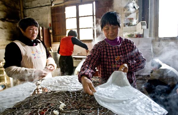 Villagers make Tenggeng, a traditional snack made of rice, in the Sizhai Village of Zhuji City, east China's Zhejiang Province, Dec. 8, 2010. 