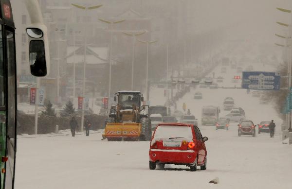 Vehicles run on the snow-covered street in Ulan Hot, north China's Inner Mongolia Autonomous Region, Dec. 10, 2010. 