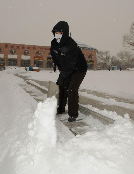 A worker cleans up the snow on the street in Ulan Hot, north China's Inner Mongolia Autonomous Region, Dec. 10, 2010. 
