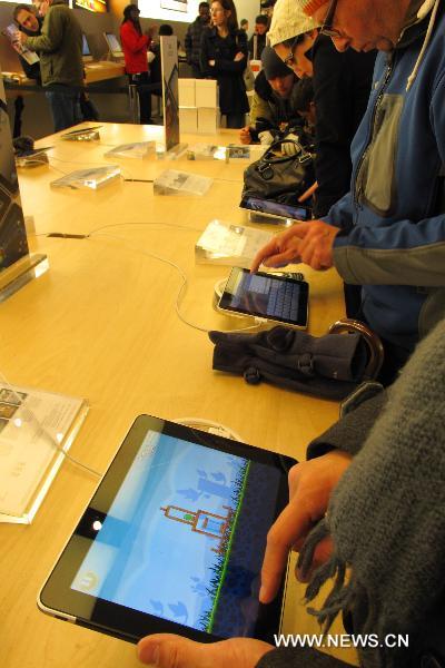 Customers play the 'Angry Birds' on iPads at the flagship store of Apple Inc. in New York, the United States, Dec. 12, 2010. 