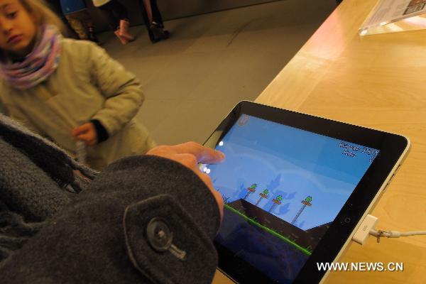 A customer plays the 'Angry Birds' on iPads at the flagship store of Apple Inc. in New York, the United States, Dec. 12, 2010. 
